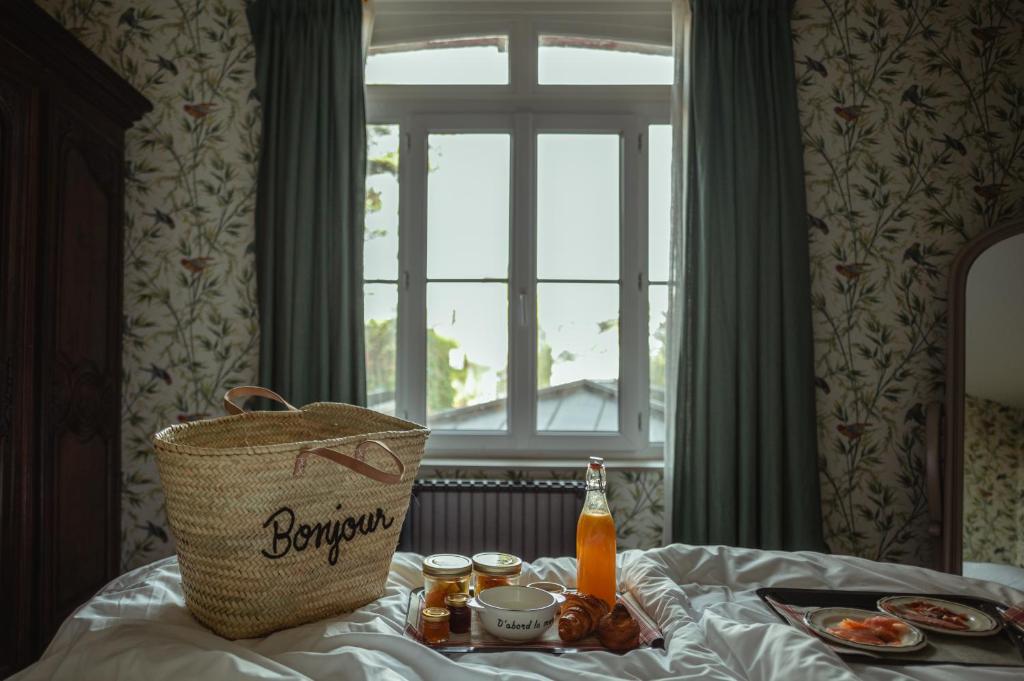a basket of food and a bottle of beer on a bed at Domaine Saint Clair - Le Donjon in Étretat