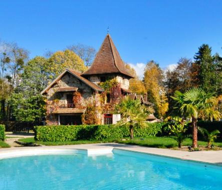 une maison avec une piscine en face de celle-ci dans l'établissement Manoir De La Comtesse, à Chailly-en-Bière