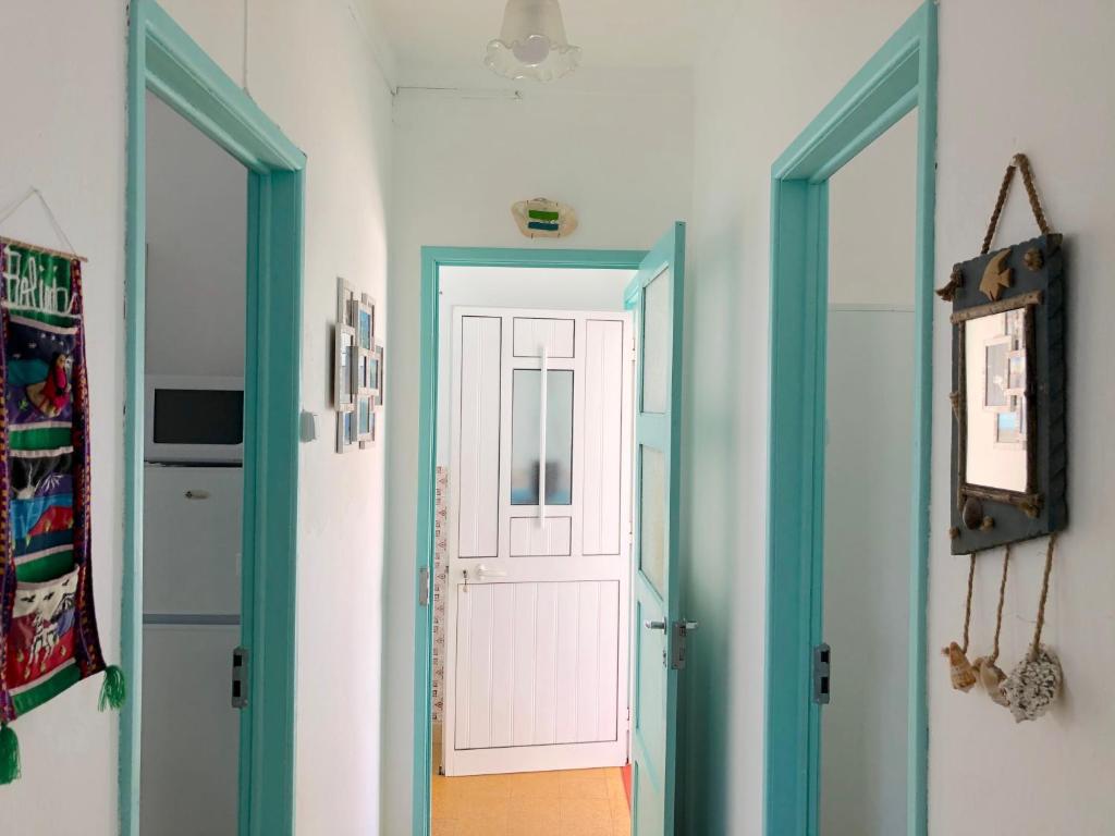 un pasillo con dos puertas y una puerta rosa en Casa do Viajante - Family, en Zambujeira do Mar
