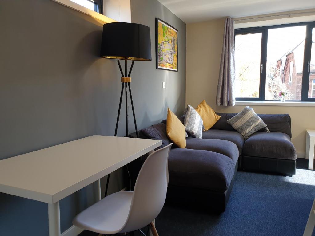 a living room with a couch and a table at Modern City Home with 5 Ensuites and Private Parking! Perfect for Working teams in Norwich