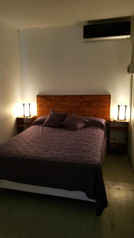 a bedroom with a large bed with two lamps at TERRABOX Apart de contenedores in Olivera
