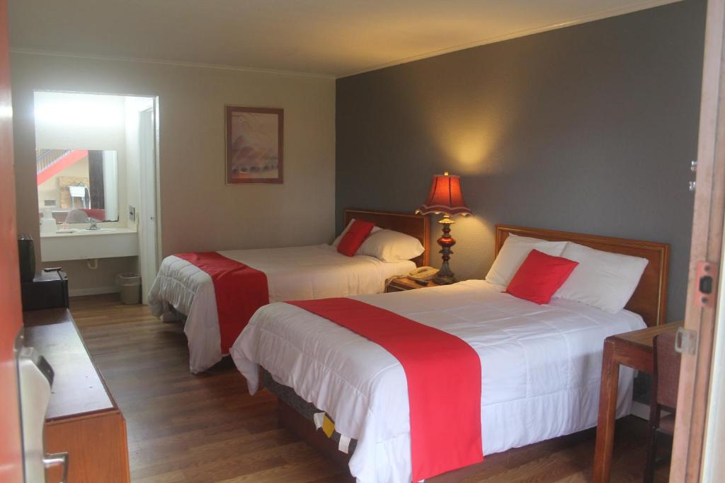 a hotel room with two beds with red and white sheets at SPRINGWOOD HOTEL, Opelika I-85 Columbus Pkwy in Opelika