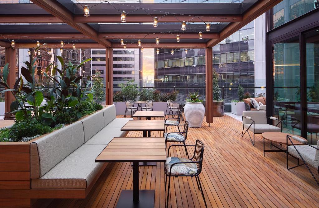 an outdoor patio with tables and chairs on a building at Little National Hotel Sydney in Sydney
