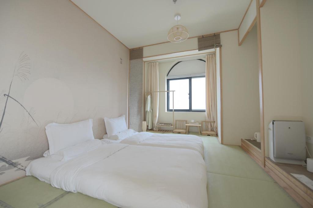 Postel nebo postele na pokoji v ubytování Shanghai Xintiandi Former French Historical Area Hotel