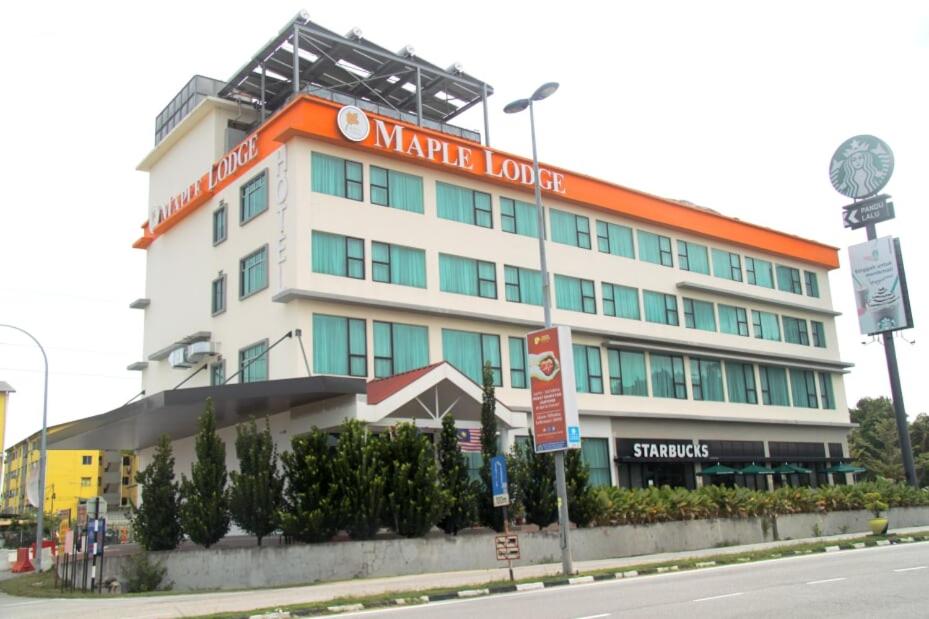 a building with a warmite hotel on the side of a street at Maple Lodge in Batu Pahat
