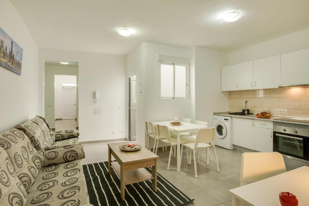 een woonkamer en een keuken met een bank en een tafel bij 1a Van Halen in Vecindario