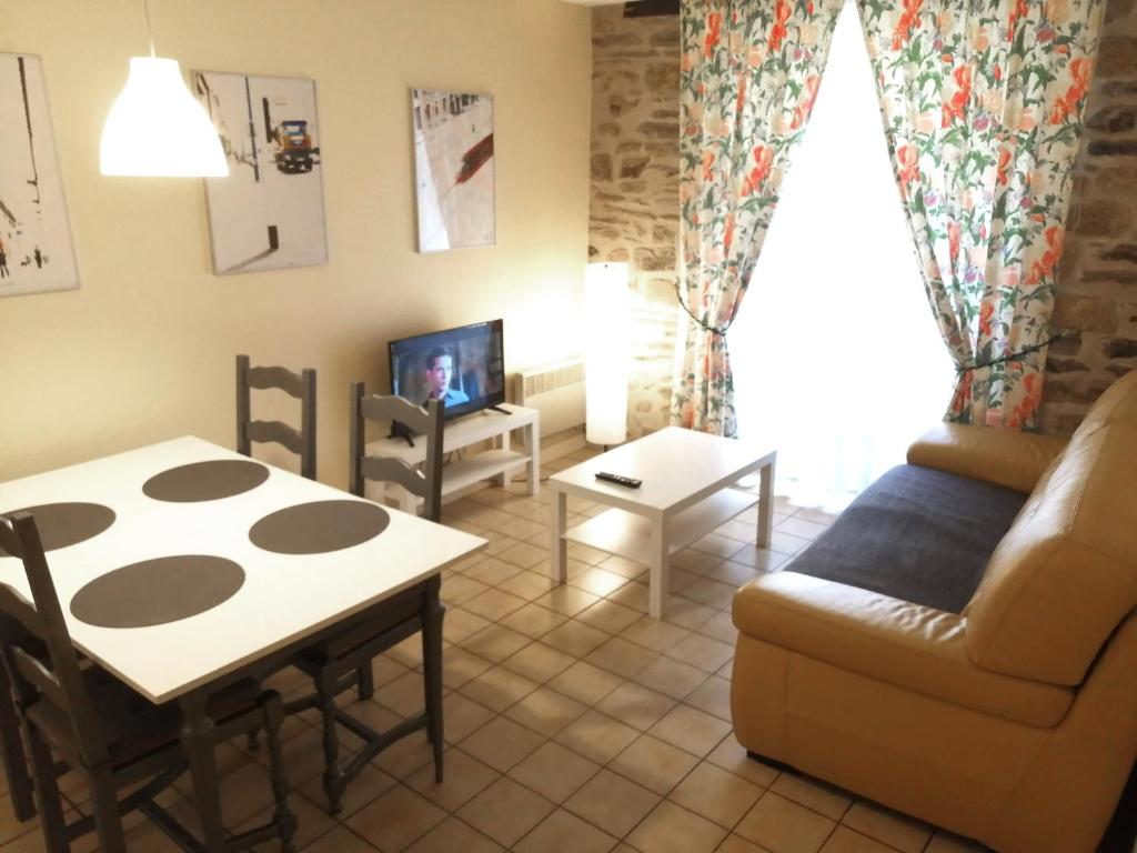 a living room with a couch and a table at Chez Gustou in Chaudes-Aigues