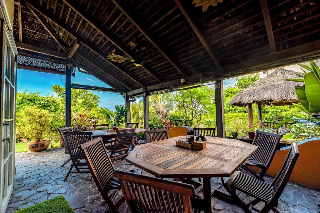 an outdoor patio with a wooden table and chairs at Red Garden Resort in Eluan
