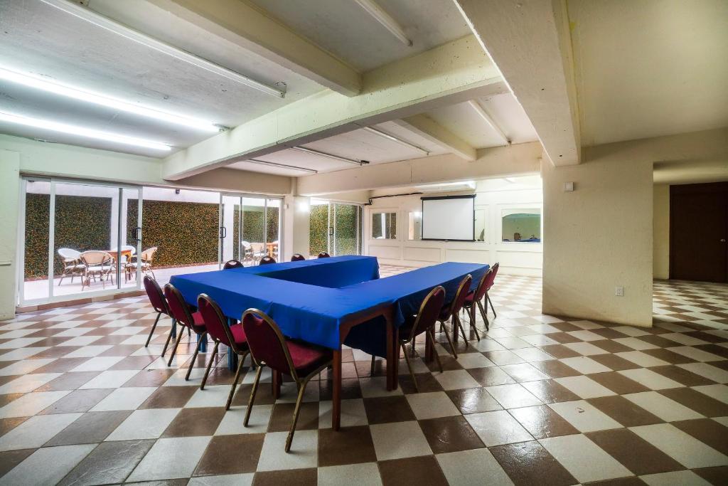 a large meeting room with a blue table and chairs at Hotel Imperial in Veracruz