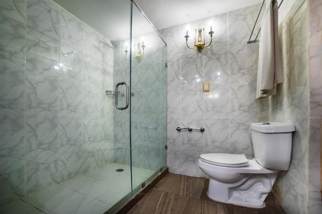a bathroom with a toilet and a glass shower at Hotel Imperial in Veracruz