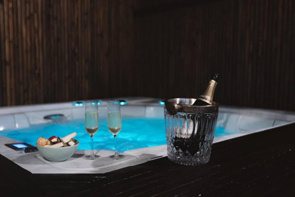 een tafel met twee glazen wijn en een fles champagne bij Green Suite & Spa in Bergen