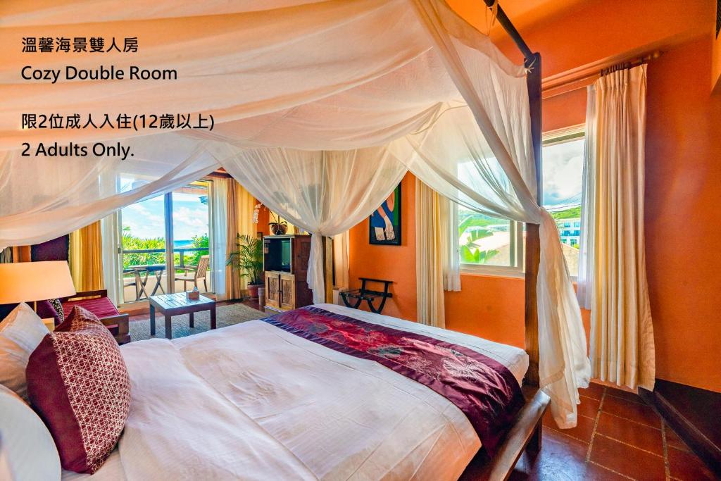 a bedroom with a canopy bed and a window at Red Garden Resort in Eluan