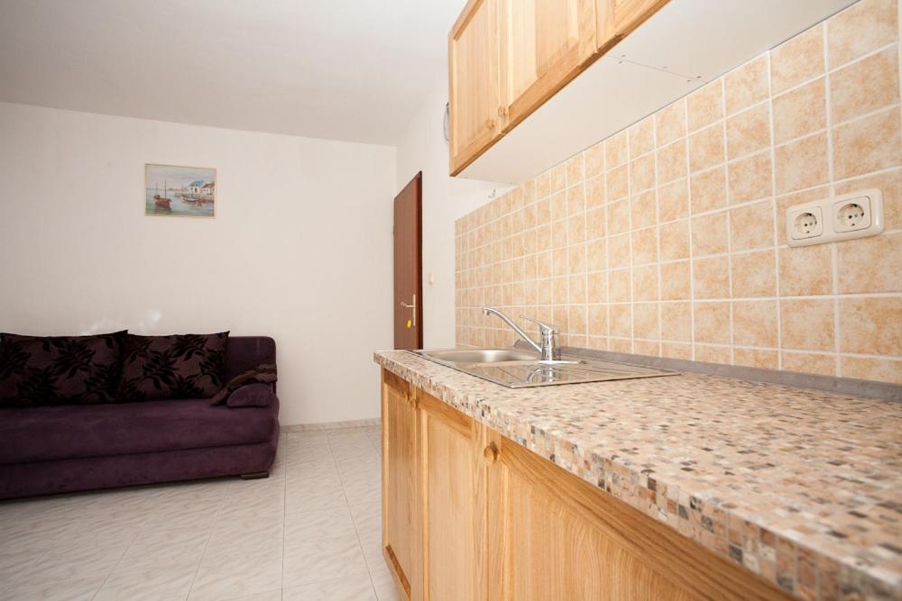 kuchnia ze zlewem i kanapą w pokoju w obiekcie Apartments Mato w Krku