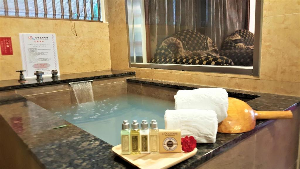 a counter with water in a bathroom with a sink at Chyuan Du Spring Resort in Taipei