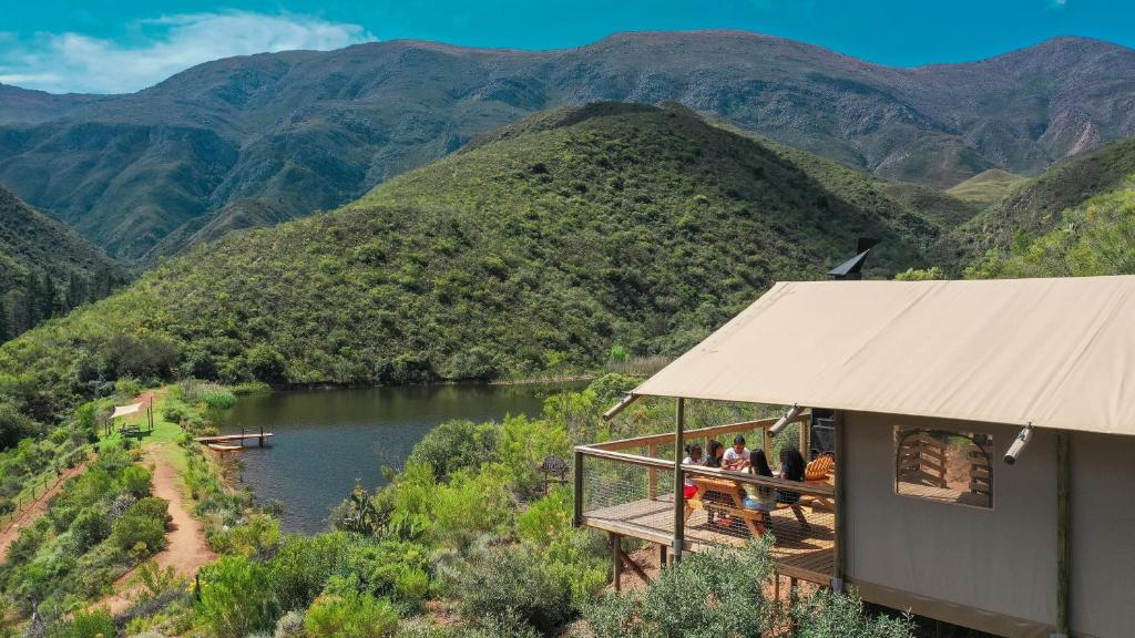 eine Gruppe von Menschen, die auf einer Terrasse mit Blick auf einen Fluss stehen in der Unterkunft AfriCamps at Pat Busch in Robertson