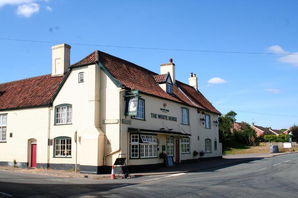 a white building on the corner of a street at The White Horse in Beyton