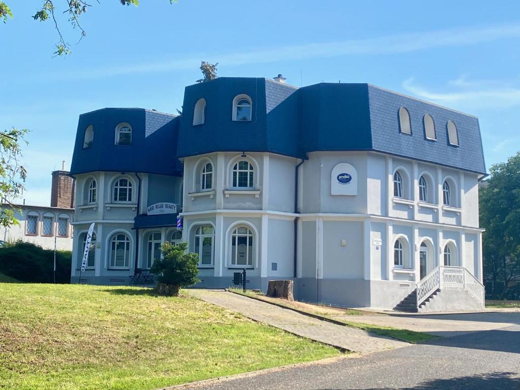 a large building with a blue roof at GrandLux Villa & Spa in Teplice