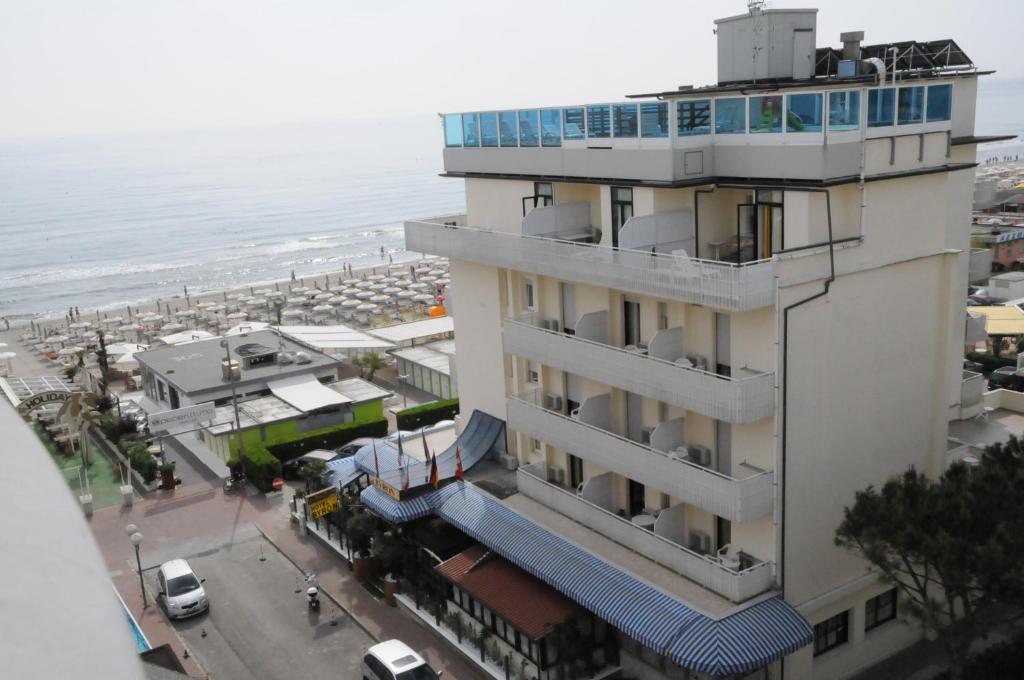 a building next to a beach with the ocean at Hotel Byron in Milano Marittima