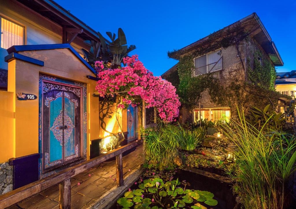 a house with pink flowers on the side of it at Red Garden Resort in Eluan