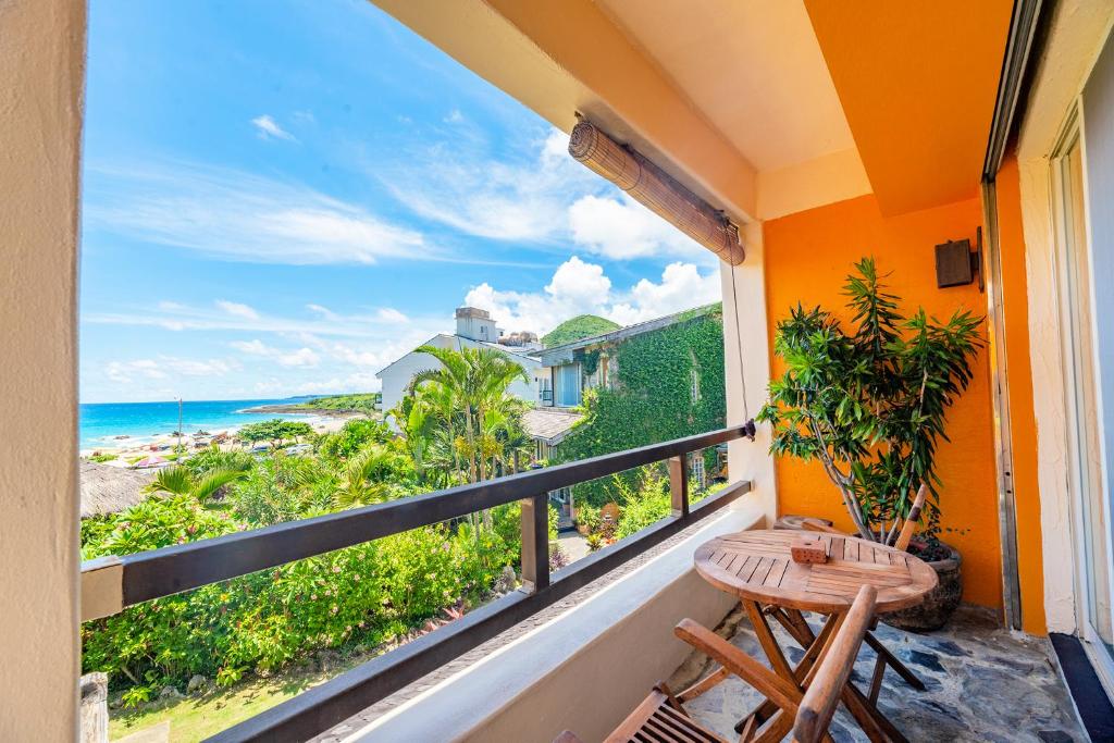 a balcony with a table and a view of the ocean at Red Garden Resort in Eluan