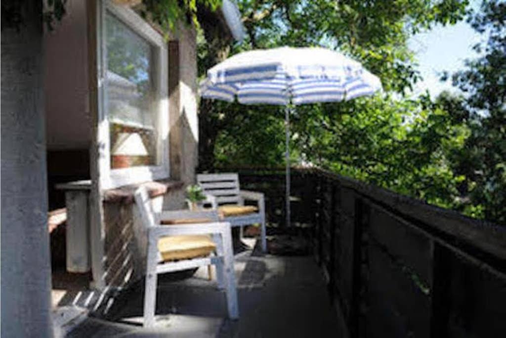 um pátio com um guarda-sol, uma mesa e cadeiras em The cozy family Retreat Lübeck em Lübeck