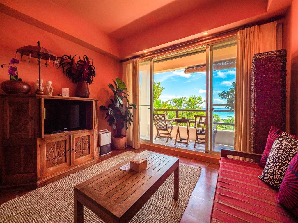 a living room with a couch and a large window at Red Garden Resort in Eluan