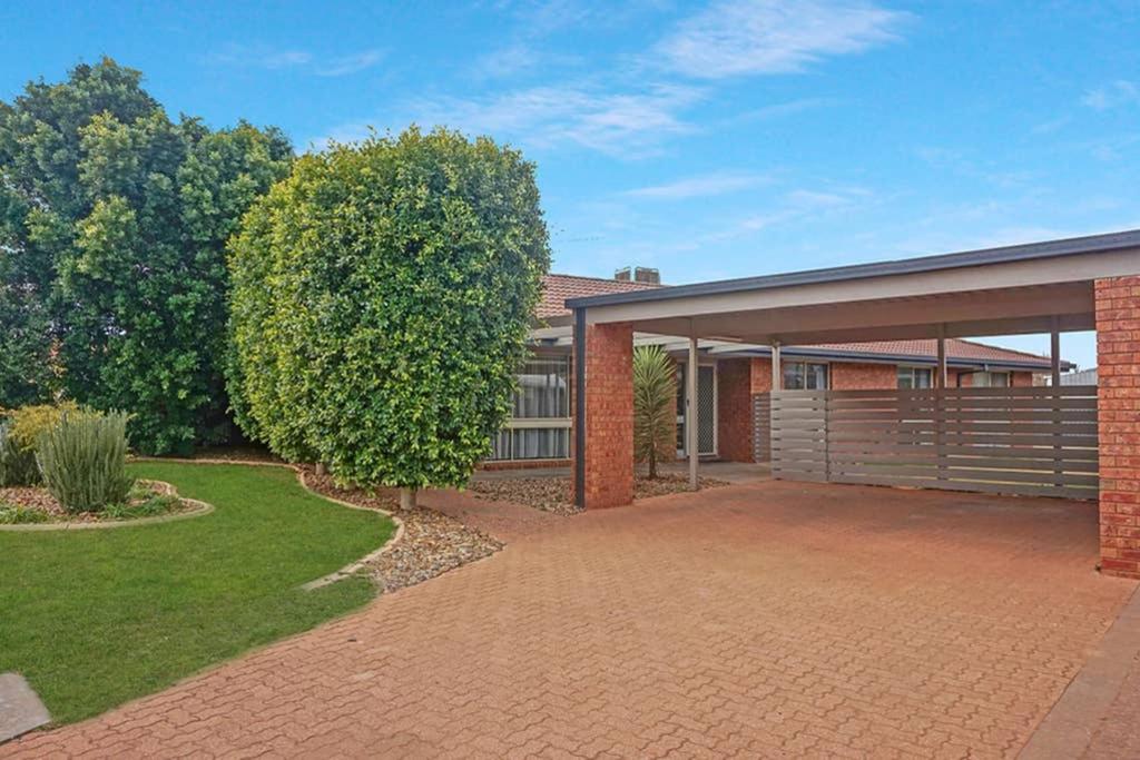 a brick house with a garage and a yard at Plantation Haven in Mildura