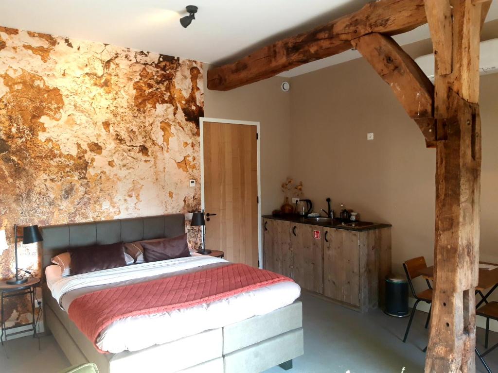 een slaapkamer met een bed en een roestige muur bij 't Buitenverblijf Erve Punte in Losser