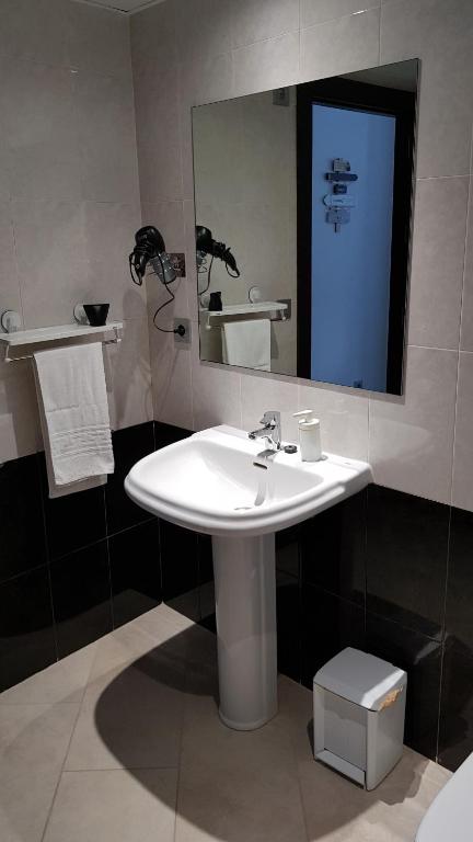 a bathroom with a white sink and a mirror at Apartamentos Cala Azul La Móra in Tarragona