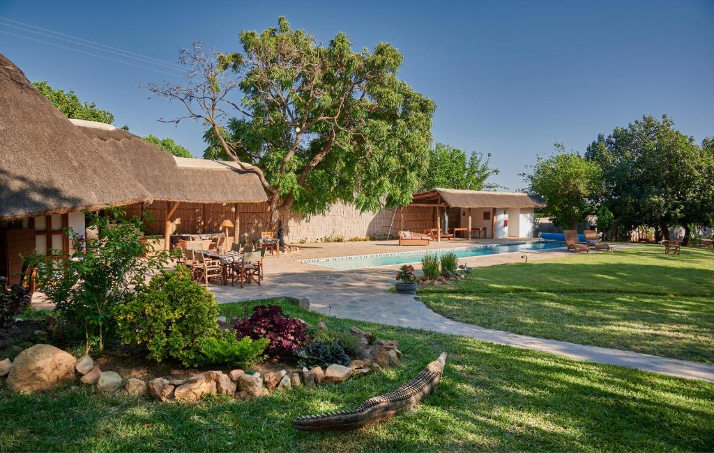ein Haus mit einem Garten mit Pool in der Unterkunft Wild Dogs Lodge in Lusaka