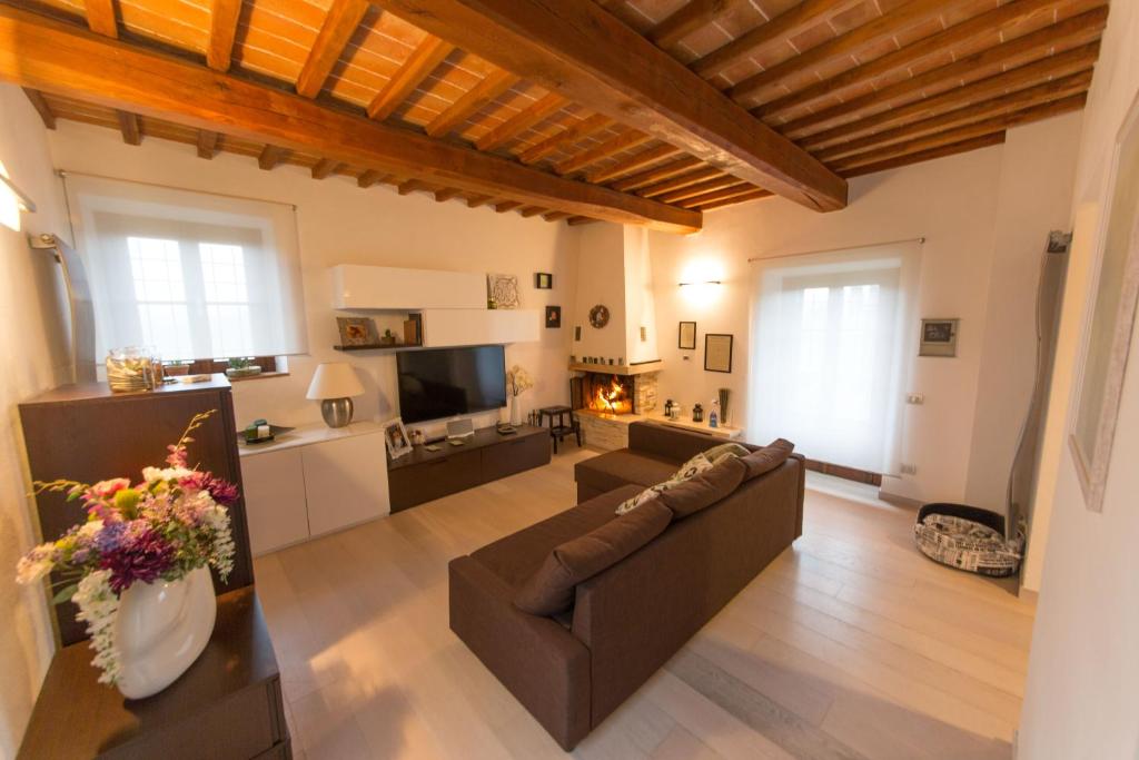een grote woonkamer met een bank en een open haard bij VILLORE - Home Sweet Home Tuscany in Poggibonsi