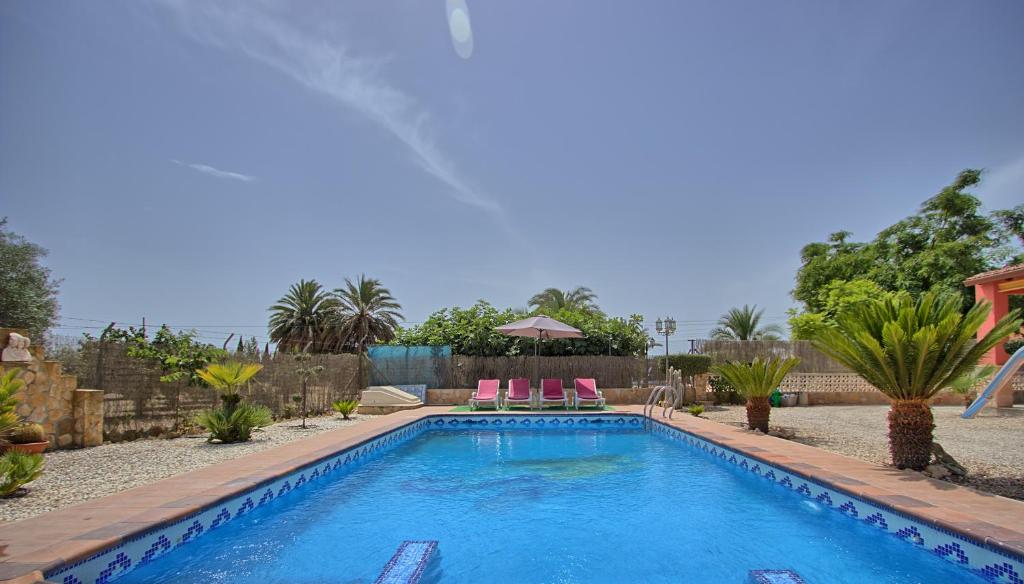 una piscina con 2 sillas rosas en un patio en 016 - Finca La Dama Valverde - comfortHOLIDAYS en Valverde Alto