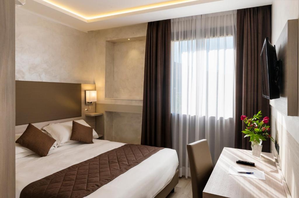 a hotel room with a bed and a desk at Hotel Plaza in Turin