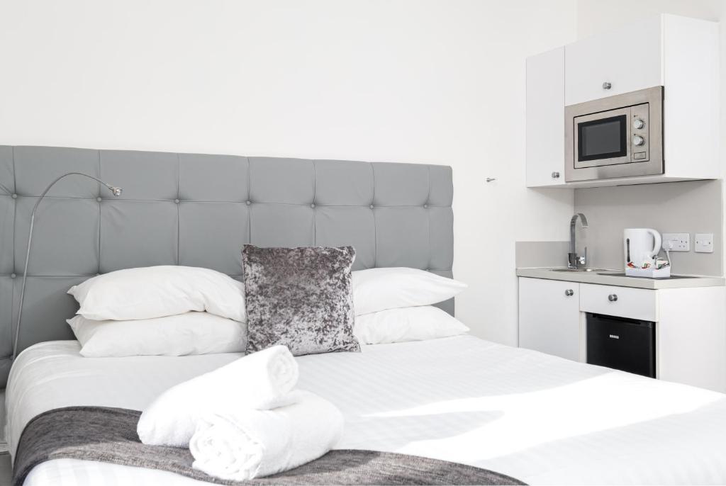 福爾柯克的住宿－Kelpies Serviced Apartments，一间卧室设有两张床,墙上配有电视。