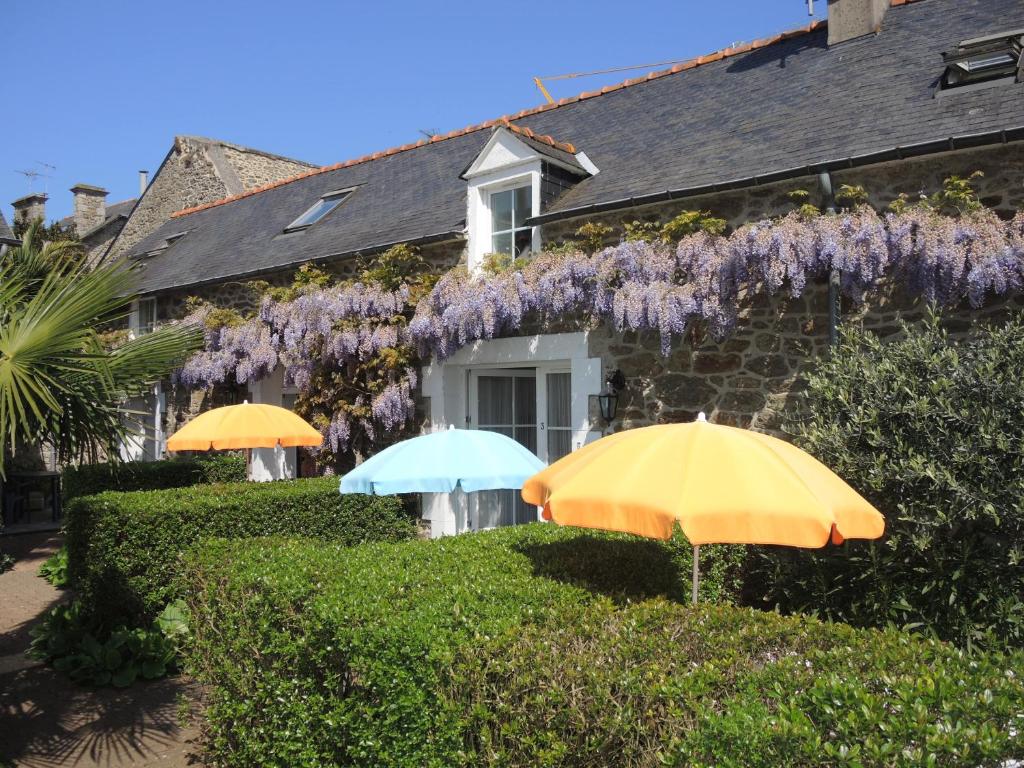 deux parapluies devant une maison avec des glycines dans l'établissement Clos de la Fontaine, à Dinard