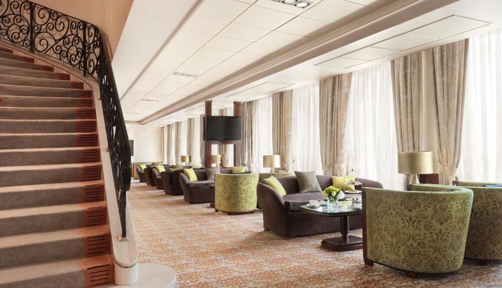 a hotel lobby with couches and chairs and a staircase at Intercontinental Cairo Citystars by IHG in Cairo