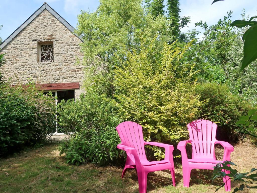 two pink chairs sitting in the yard of a house at Holiday Home La Grange - LOY110 by Interhome in Pont-lʼAbbé