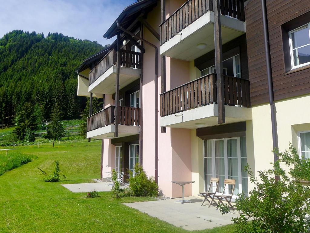 a building with two balconies and a grass yard at Apartment Andromède 3-pièces A34 by Interhome in Moleson