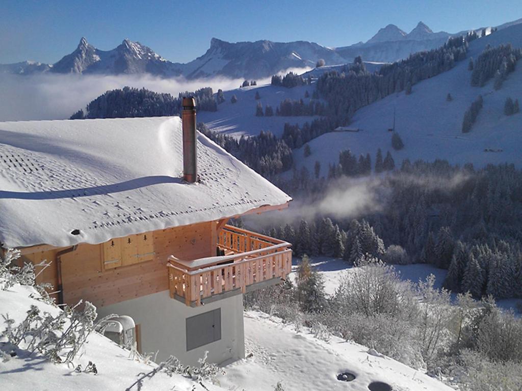 a building with a snow covered roof on a mountain at Chalet Chalet La Poya by Interhome in Moleson