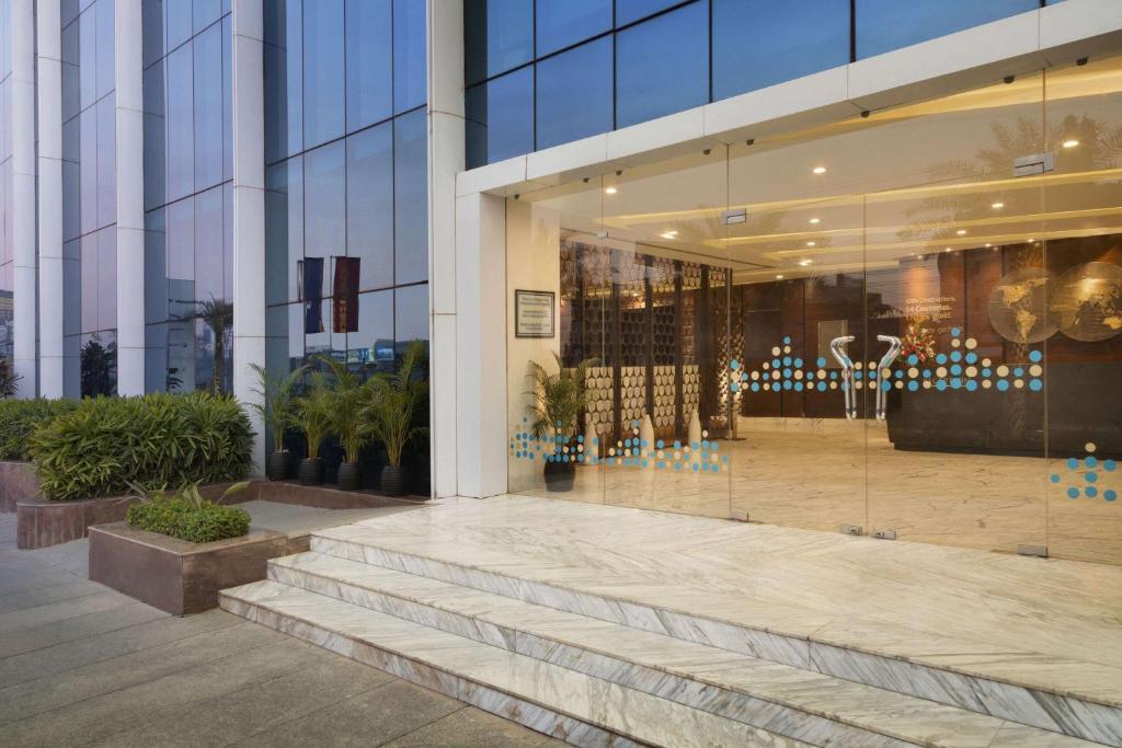 a glass building with stairs in front of it at Howard Johnson By Wyndham, Hebbal, Bengaluru in Bangalore