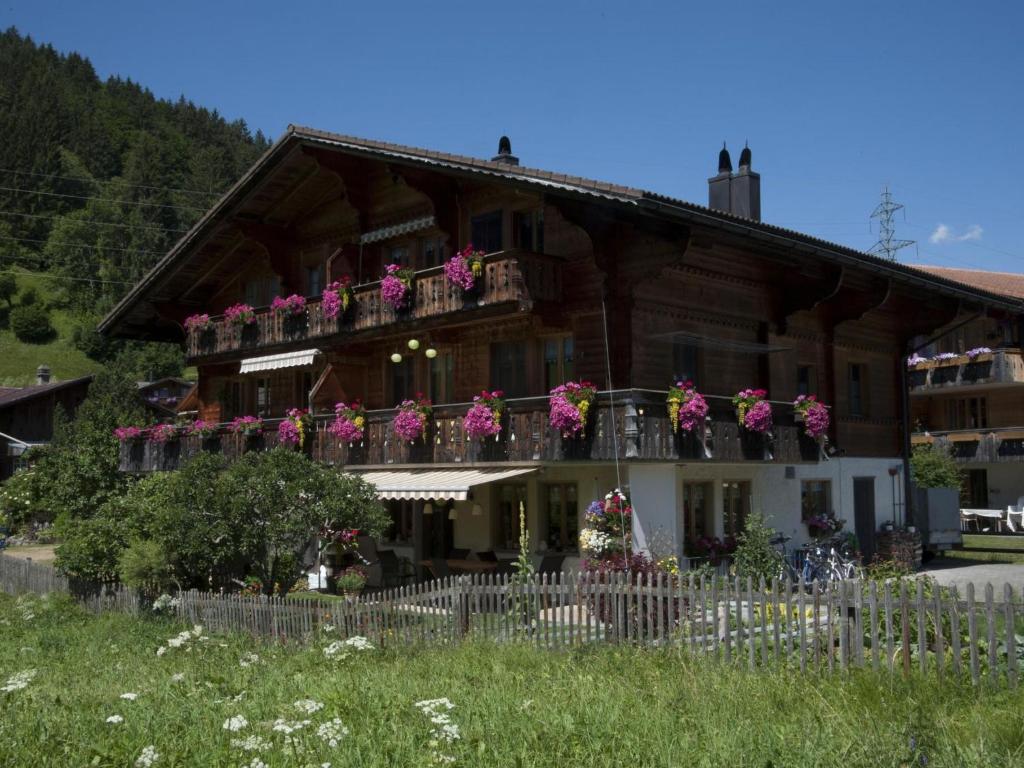 ein Gebäude mit einem Balkon mit Blumen darauf in der Unterkunft Apartment Steimandli by Interhome in Gstaad