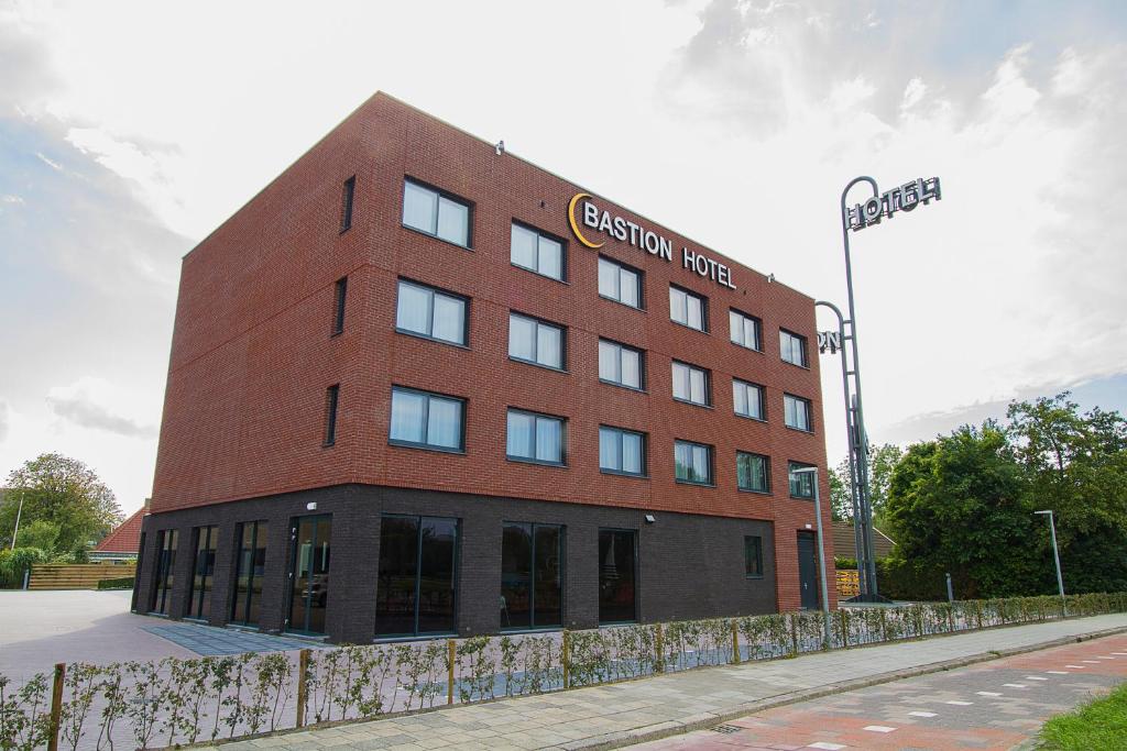 un edificio de ladrillo rojo al lado de una calle en Bastion Hotel Leeuwarden, en Leeuwarden