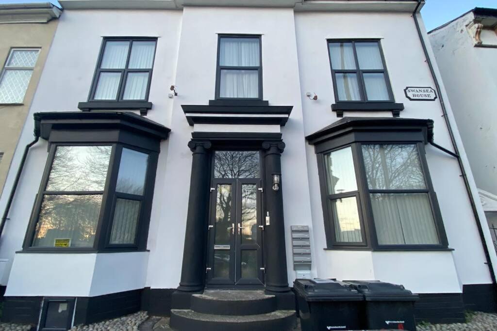 Casa blanca con puertas y ventanas negras en Swansea house en Birmingham