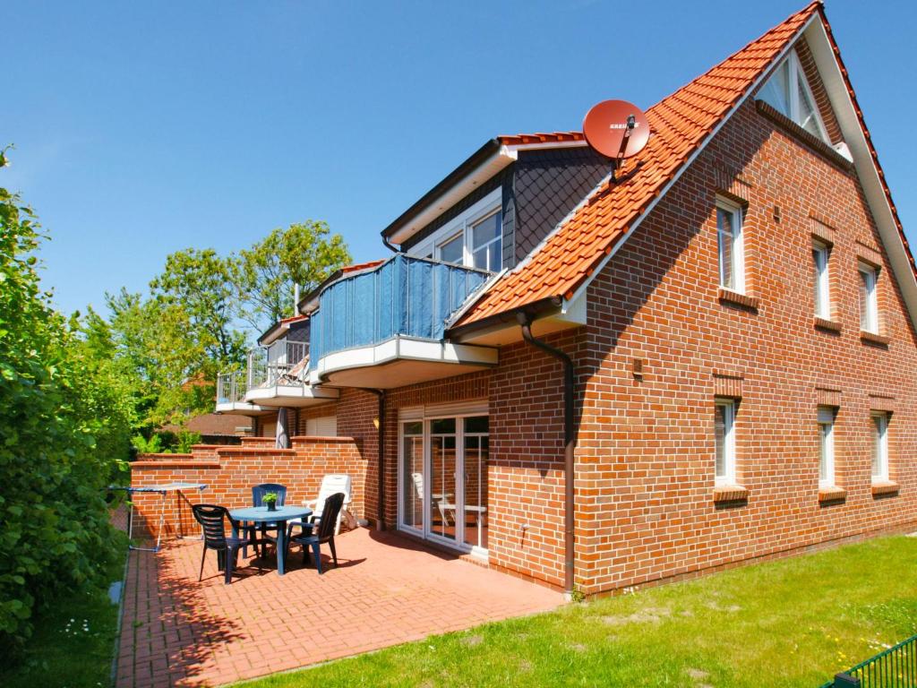 una casa in mattoni con patio e tavolo di Apartment Windlicht by Interhome a Norddeich