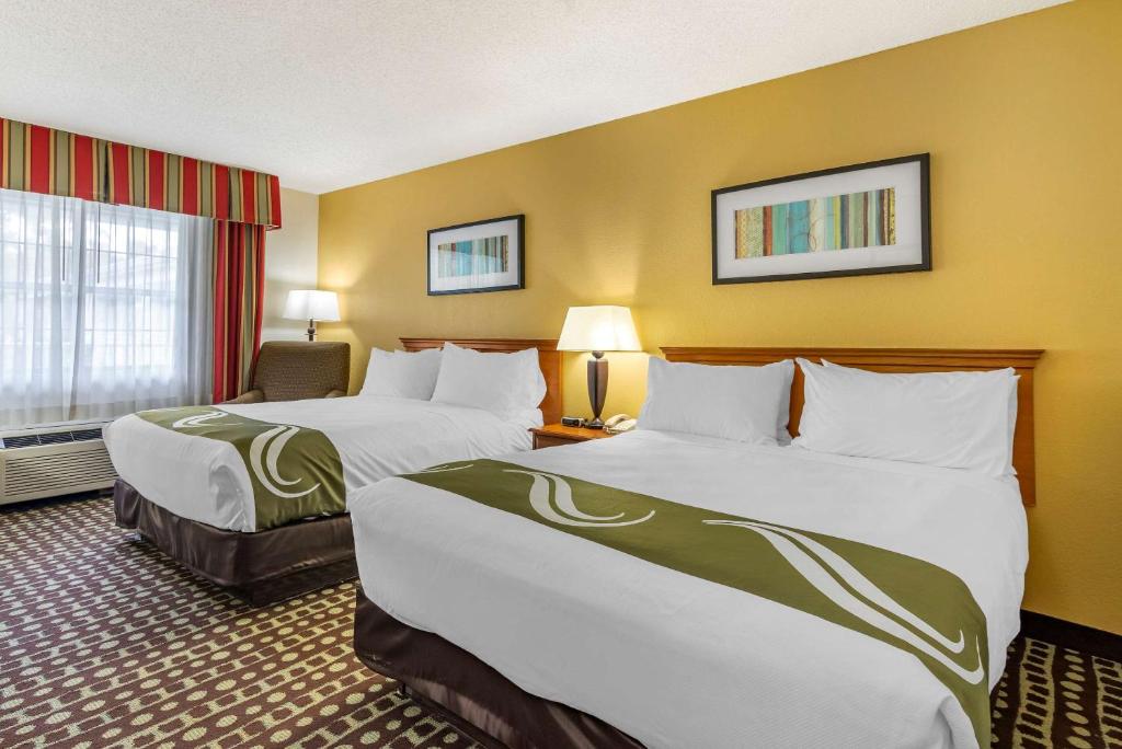 um quarto de hotel com duas camas e uma janela em Quality Inn Fayetteville Near Historic Downtown Square em Fayetteville