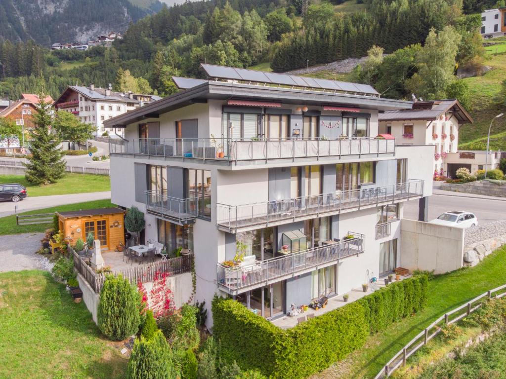 a large white building with balconies on a hill at Apartment Flirscherblick by Interhome in Flirsch