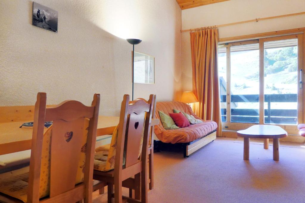 a living room with a table and a couch at Residence Arpasson II in Méribel