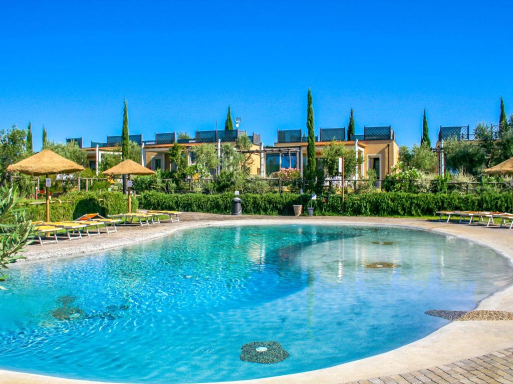 una grande piscina con sedie e ombrelloni di Holiday Home Di Toscana Holidays by Interhome a Collemezzano