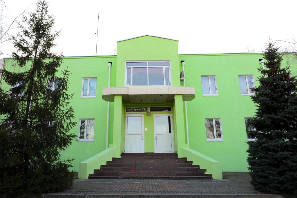 a green building with stairs leading to the front door at Hotel Uyut in Kremenchuk