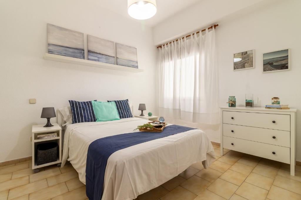 ラスパルマス・デ・グランカナリアにあるApartment Las Canteras Beachのベッドルーム1室(青と白の毛布付きのベッド1台付)